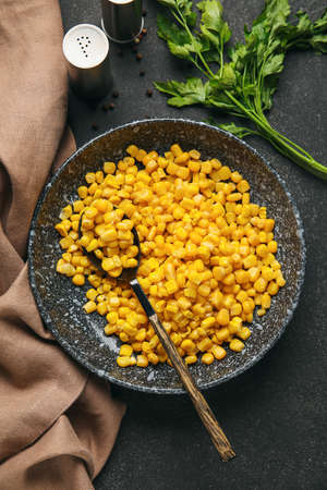 Bowl with corn kernels and spices on dark backgroundの写真素材