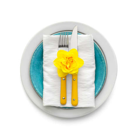 Beautiful table setting with narcissus flower on white background