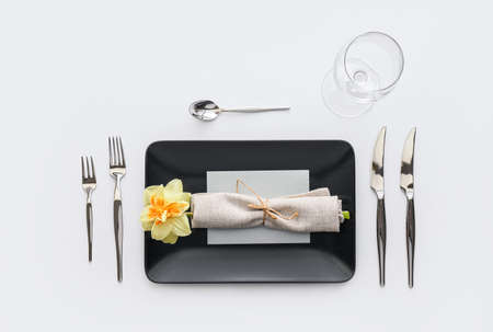 Beautiful table setting with narcissus flower on white background