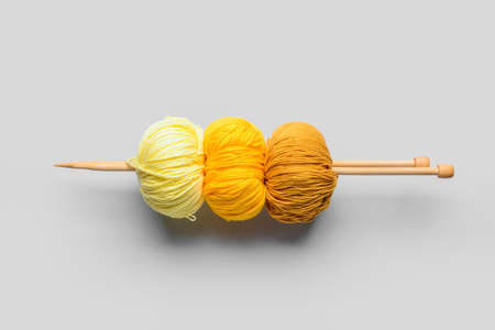 Yarn and knitting needles on white background