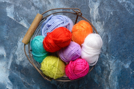 Basket with knitting yarn on color background