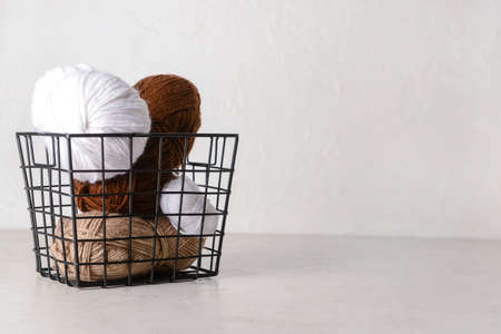 Basket with knitting yarn on light tableの写真素材