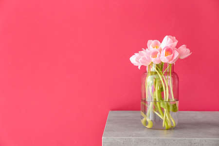 Vase with beautiful tulip flowers on table
