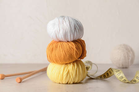 Knitting yarn, needles and measuring tape on light table