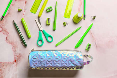 Colorful stationery and pencil case on light background