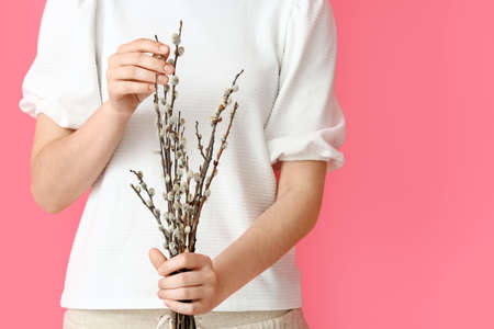 Woman with willow branches on color backgroundの写真素材