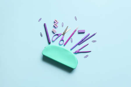 Composition with pencil case and stationery on blue background