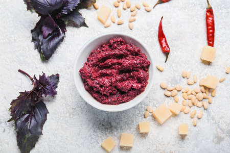 Composition with bowl of pesto sauce and ingredients on light backgroundの写真素材