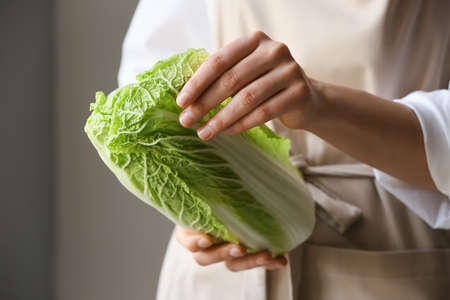 Woman holding fresh chinese cabbage, closeupの写真素材