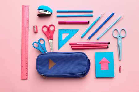 Composition with pencil case and stationery on color background