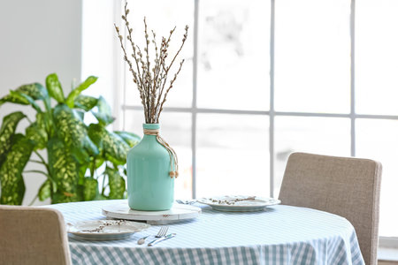 Vase with willow branches on table in dining roomの写真素材