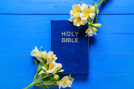 Holy Bible with flowers on blue wooden backgroundの写真素材