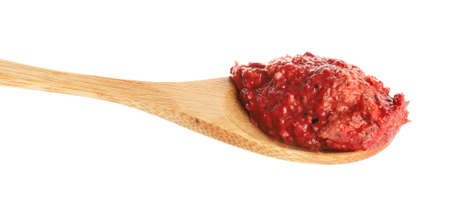Spoon of tasty pesto sauce on white background