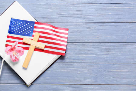 Book with flag of USA, cross and flower on blue wooden backgroundの写真素材