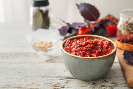 Bowl of tasty pesto sauce on wooden tableの写真素材