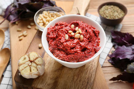 Composition with bowl of tasty pesto sauce and ingredients on wooden backgroundの写真素材