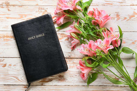 Holy Bible and lily flowers on light wooden backgroundの写真素材