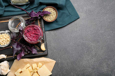 Composition with jar of tasty pesto sauce and ingredients on dark backgroundの写真素材