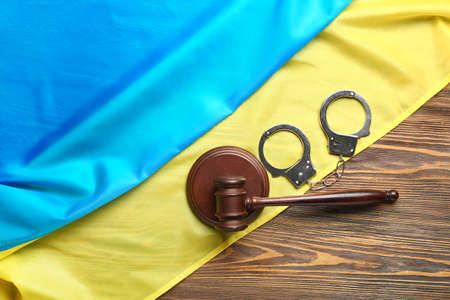 Judge gavel and handcuffs with flag of Ukraine on wooden backgroundの写真素材
