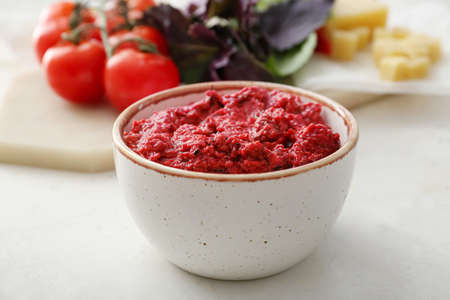 Bowl of tasty pesto sauce on light backgroundの写真素材