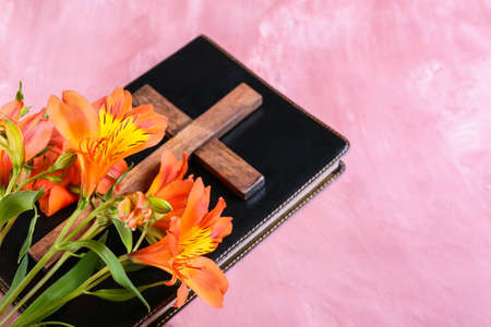 Holy Bible with cross and flowers on pink backgroundの写真素材