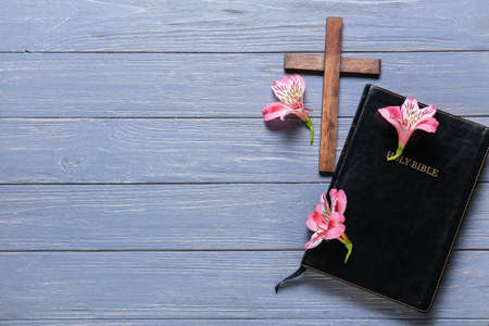 Holy Bible with lily flowers and cross on blue wooden backgroundの写真素材