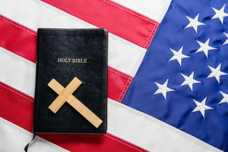 Holy Bible with wooden cross on flag of USAの写真素材