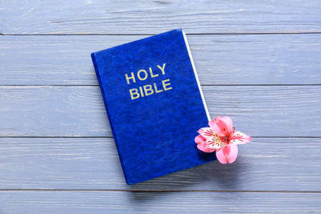 Holy Bible with lily flower on blue wooden backgroundの写真素材