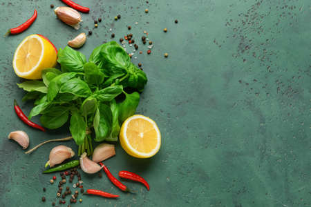 Fresh basil leaves, lemon and spices on color backgroundの写真素材