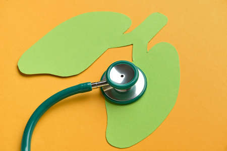 Paper lungs with stethoscope on orange backgroundの写真素材