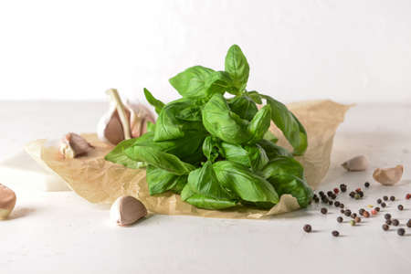 Fresh basil leaves, garlic and peppercorns on light backgroundの写真素材