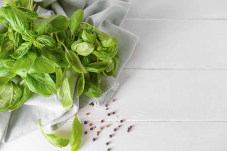 Fresh basil leaves and peppercorns on light wooden backgroundの写真素材