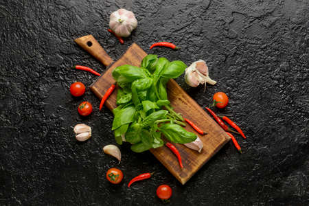 Fresh basil leaves and different products on dark backgroundの写真素材