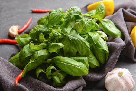 Composition with fresh basil, lemon and spices on dark backgroundの写真素材