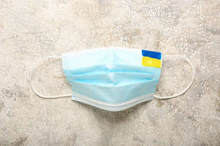 Medical mask with drawn Ukrainian flag on grunge backgroundの写真素材