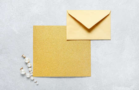 Blank card with envelope and earrings on white background