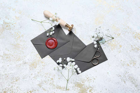Envelopes with wedding rings, flowers and stamp on white backgroundの写真素材