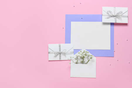 Blank card and envelopes with flowers on pink backgroundの写真素材