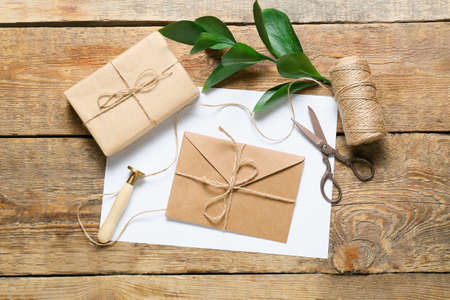 Envelope with stamp, scissors and box on wooden backgroundの写真素材