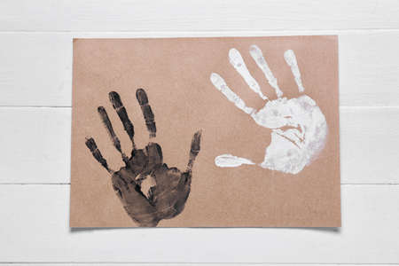 Paper with different handprints on white wooden background. concept of racismの写真素材