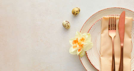 Beautiful table setting with narcissus flowers on light backgroundの写真素材