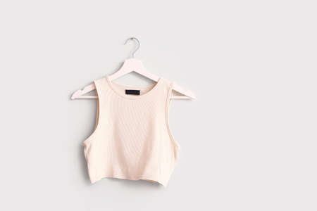 Hanger with stylish top on white background