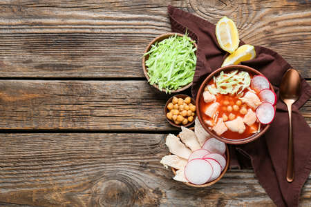 Bowl with delicious pozole soup and ingredients on wooden backgroundの写真素材