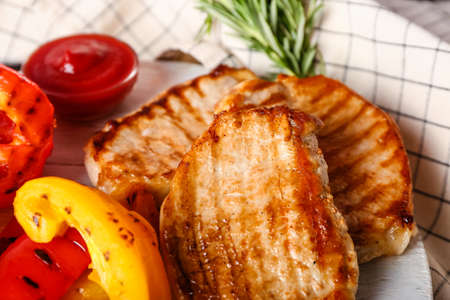 Board with tasty grilled vegetables and steaks, closeupの写真素材