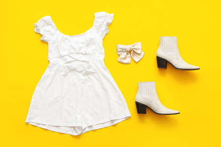 Stylish summer overall jumpsuit, shoes and hair bow on color backgroundの写真素材