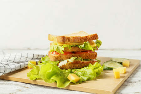 Board with tasty sandwich on table, closeupの写真素材