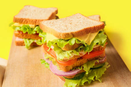 Board with tasty sandwiches on color background, closeupの写真素材
