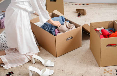 Young woman arranging clothes at wardrobeの写真素材