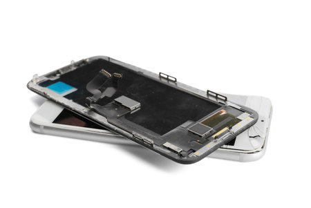 Mobile phone with broken screen and display module on white background