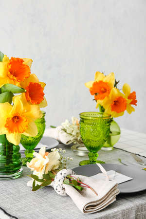 Beautiful table setting with narcissus flowersの写真素材